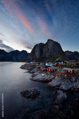 Red fishing huts (rorbu) in Hamnoy village, Norway, in evening l