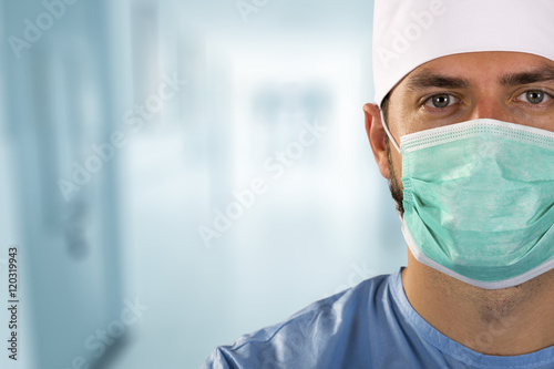 doctor surgeon with face mask standing in the hospital hallway