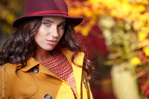 Fashionable woman and fall yellow, red  maple park  background.
