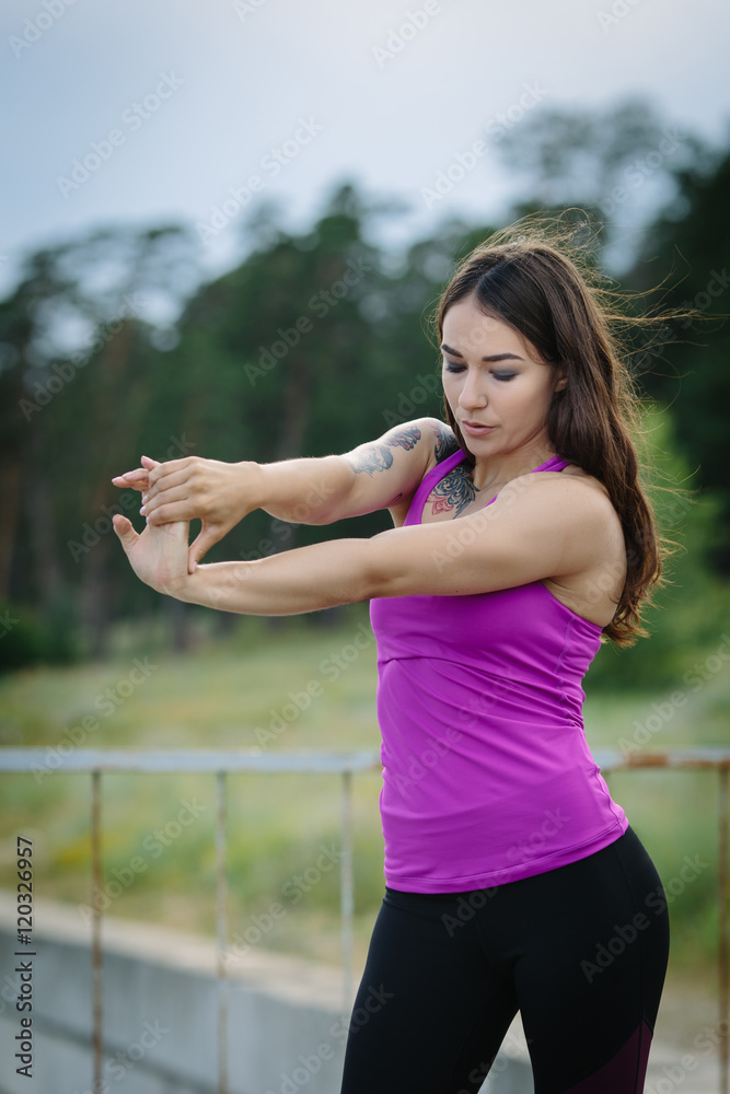 Sporty young woman warming up before running in the city Sporty young woman warming up before running in the city