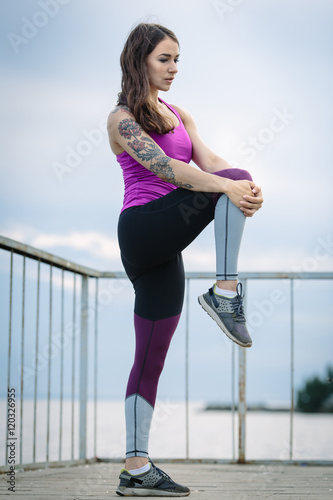 Sporty young woman warming up before running in the city