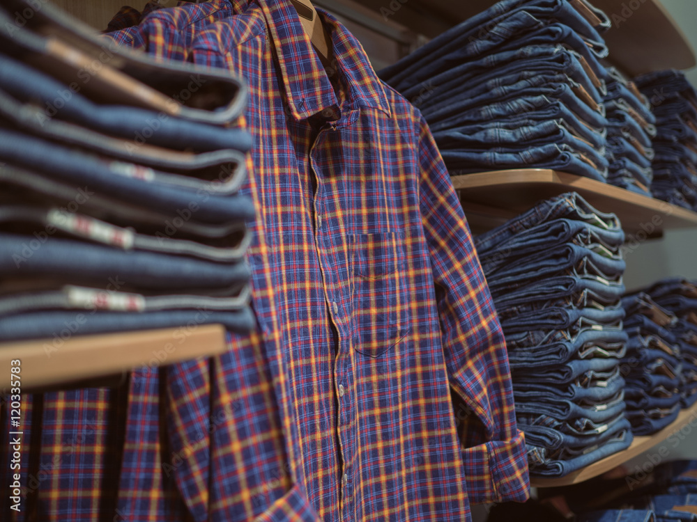 Obraz premium Shelves jeanswear. Retro Plaid shirt on the background of denim
