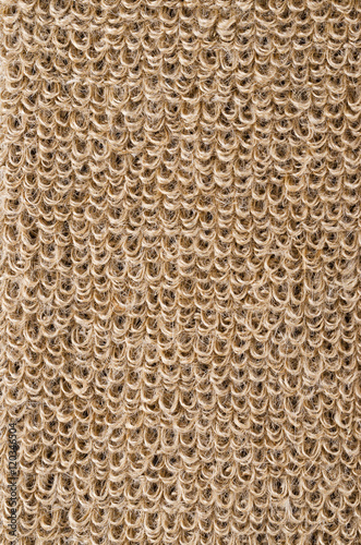 Rough flax fabric with loops. Natural flax fibres are processed to a coarse fabric  used for massage straps and gloves. Solid yarn with brown ochre color. Isolated macro photo close up.