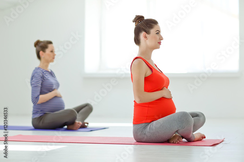 Fototapeta Naklejka Na Ścianę i Meble -  Two pregnant women making yoga