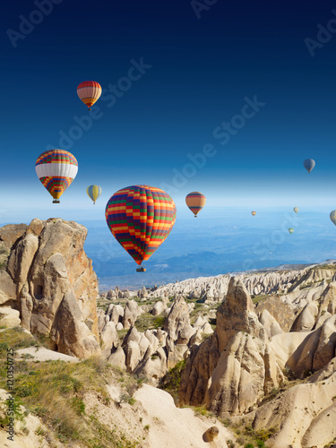 Hot air balloons flies in clear deep blue sky in Cappadocia