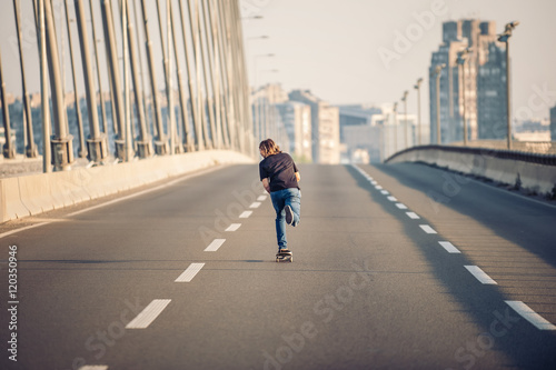 Skateboarder riding a skate over a city road bridge. Free ride s
