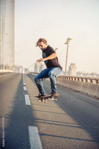 Skateboarder riding a skate and doing jumps on the city road bri © guruXOX
