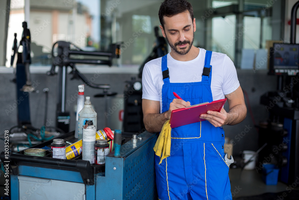 Concentrated mechanic writing on clipboard