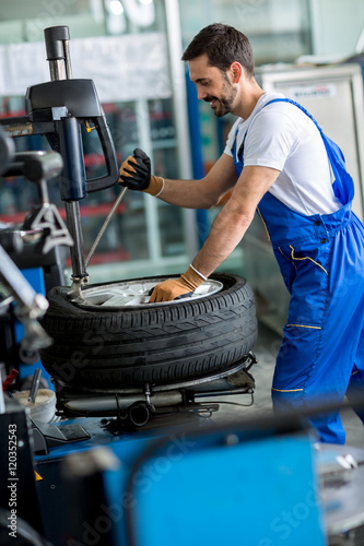 mechanic repairman balancing  car wheel photo