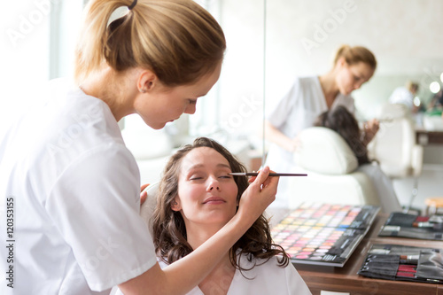 Two young beautician students working during make up classes photo