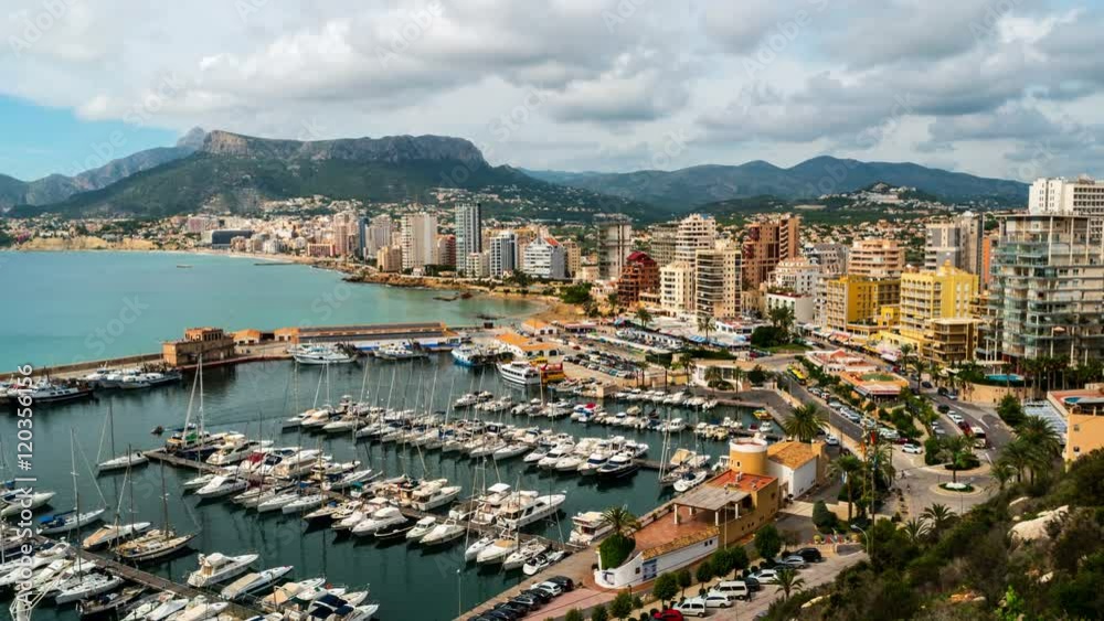 Aerial view of Calpe, Costa Blanca during the day. Popular summer resort in Spain with mediterranean sea and Las Salinas lake, mountains at the background, skyscrapers - hotels, apartments. Time-lapse