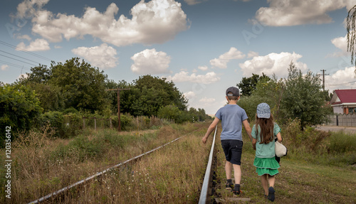 Children alone walking down old train track