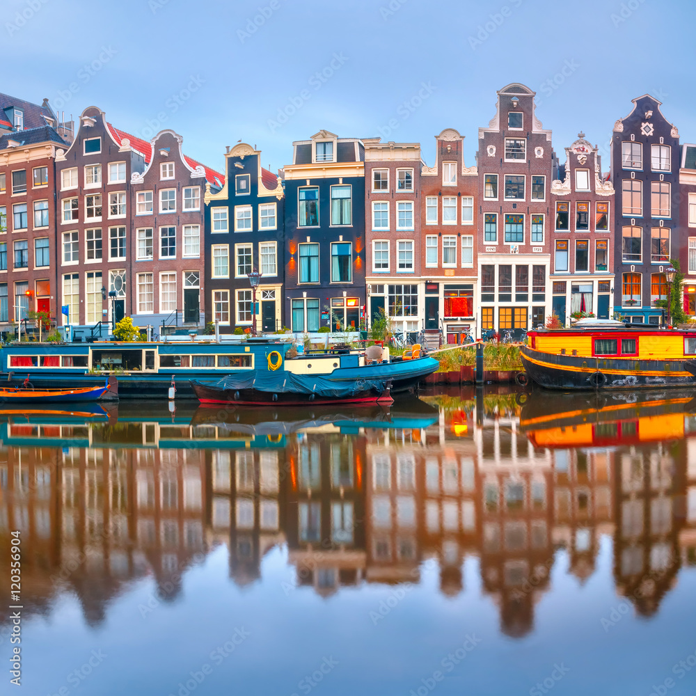 Fototapeta premium Kanał Amsterdam Singel z typowymi holenderskimi domami i łodziami mieszkalnymi w porannej niebieskiej godzinie, Holandia, Holandia.