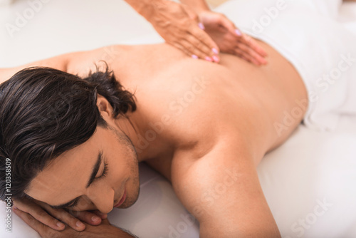 man enjoying massage treatment at spa