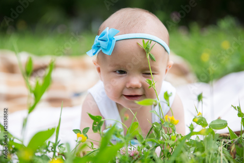 Baby girl crawling on the grass. Selective focus her eyes.