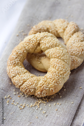 Two homemade bagels with sesame on a gray canvas