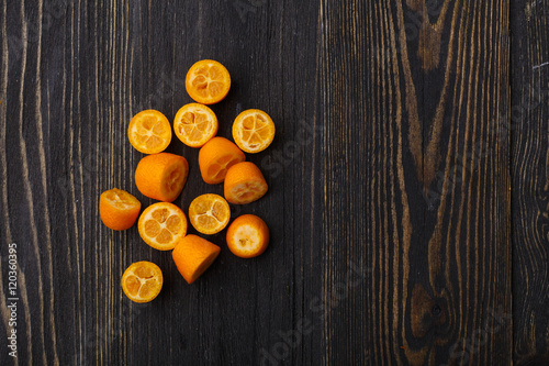 kumquat on a black wooden background 