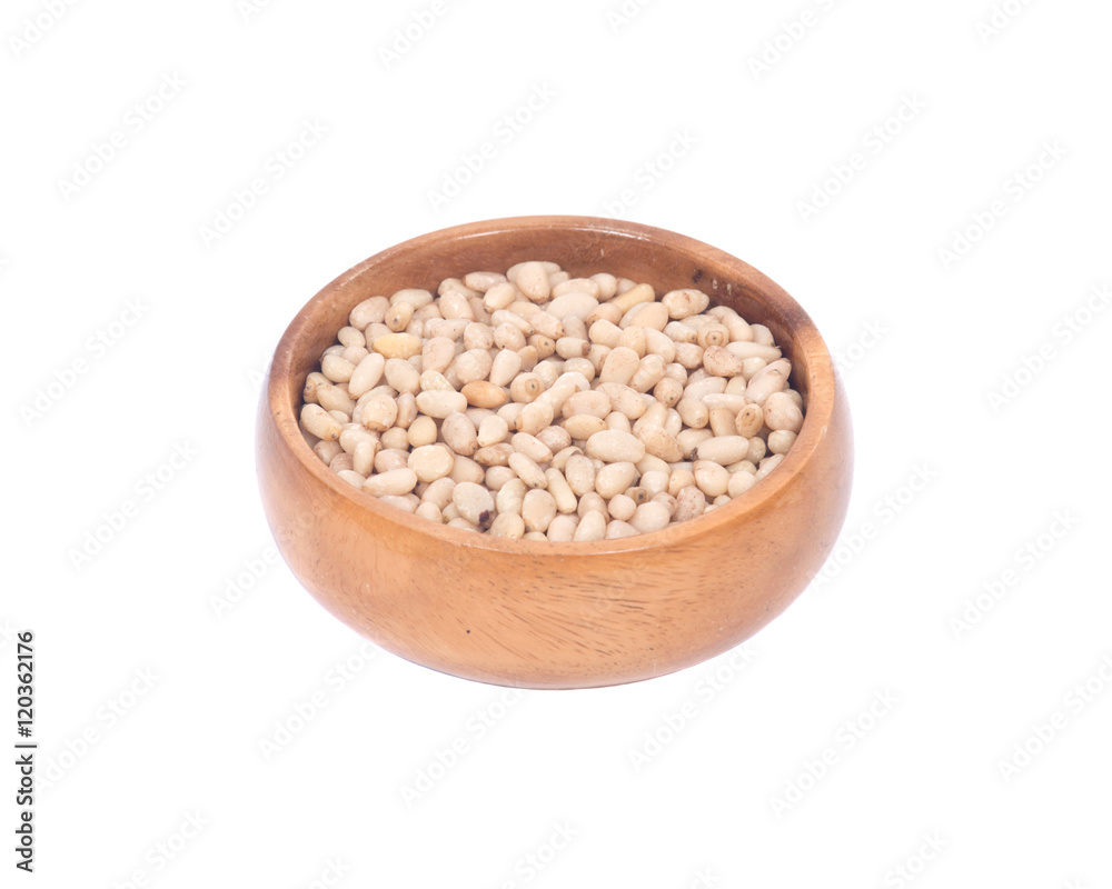 Organic pine nuts in wooden bowl separated on white background Organic pine nuts in wooden bowl separated on white background