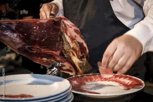 Cortador de jamón cortando un cinco jotas. degustación de jamón ibérico de bellota. Noches gastronómicas de verano.