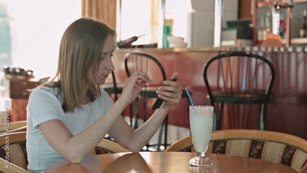 Woman using smartphone in cafe in cafe on cruise ship Woman using smartphone in cafe in cafe on cruise ship