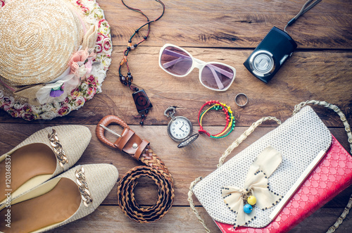 accessories for teenage girl on her vacation, hat, stylish for summer sunglasses, leather bag, shoes and costume on wooden floor
