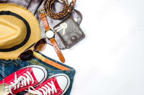 Apparel, equipment and tools for travel on a wooden floor with a white space in the background to add text to it.