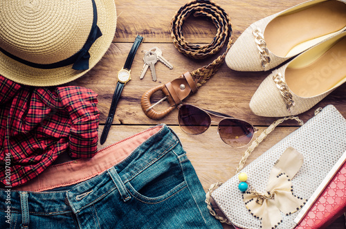 accessories for teenage girl on her vacation, hat, stylish for summer sunglasses, leather bag, shoes and costume on wooden floor.