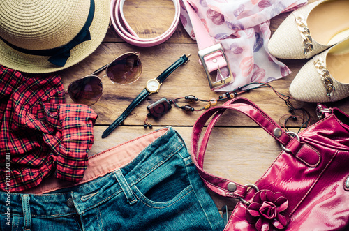 accessories for teenage girl on her vacation, hat, stylish for summer sunglasses, leather bag, shoes and costume on wooden floor.