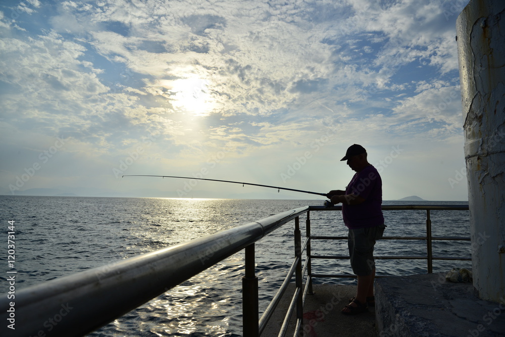 Fisherman and majestic sunset Summer holidays Greece