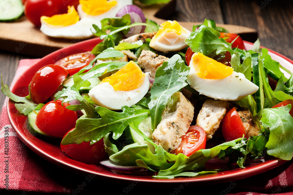 Fresh salad with chicken, tomatoes, eggs and arugula on plate Fresh salad with chicken, tomatoes, eggs and arugula on plate