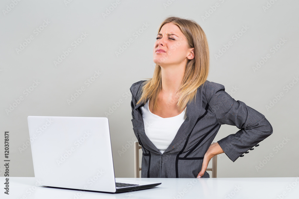 Beautiful businesswoman is having pain in her back while she is working.
Beautiful businesswoman is having pain in her back while she is working.