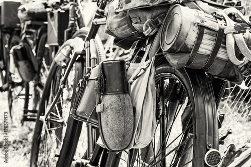 Old military bicycle with kitbag and equipments, black and white photo