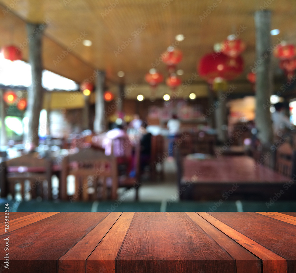Empty brown wooden table surface and resterant interior with blur background image, for product display montage,can be used for montage or display your products.