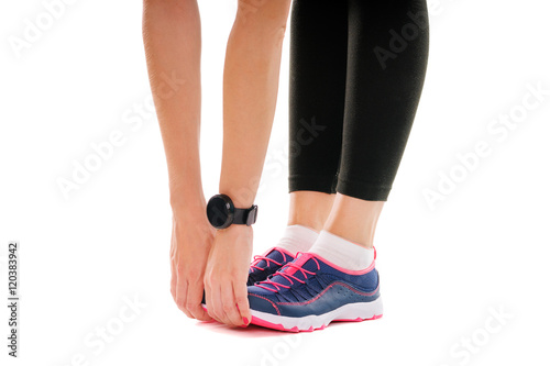 Lifestyle, sport and technology. Close up of female hands with smartwatch and legs in sneakers. Isolated on white.