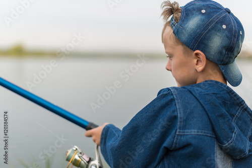 child on a summer fishing on the shore