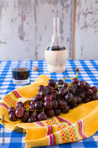 Fototapeta Naklejka Na Ścianę i Meble -  Bunch of red grapes and a glass of red wine with a wine flask