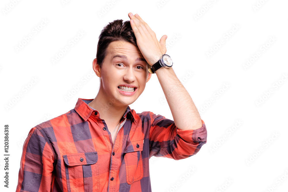 Facepalm! Studio portrait of disappointed young man holding hand on his head. Facepalm! Studio portrait of disappointed young man holding hand on his head.