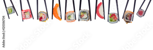 A lot of sushi and rolls in black chopsticks isolated on white background