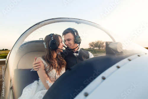 Happy young couple in headphones smiling in the cockpit. Travel concept photo