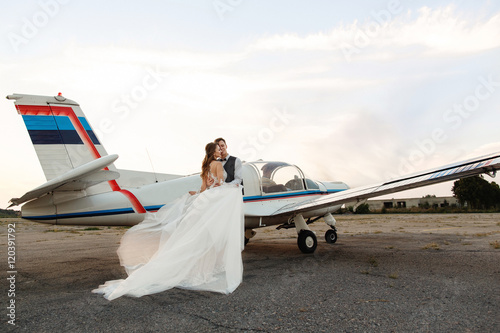 Bride and groom near the aircraft. Wedding travel concept photo