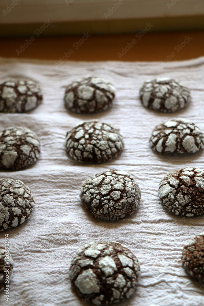 Chocolate crackle cookies organized on white napkin. Decorated with granulated and powdered sugar. Selective focus. Chocolate crackle cookies organized on white napkin. Decorated with granulated and powdered sugar. Selective focus.