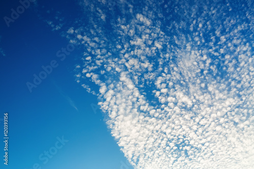 Blue sky with many fluffy white clouds. Beautiful blue sky background.