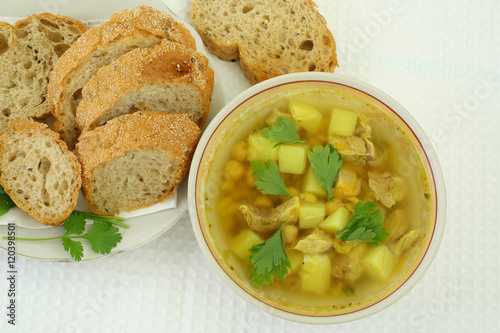 soup of chickpeas and sliced bread on white plates