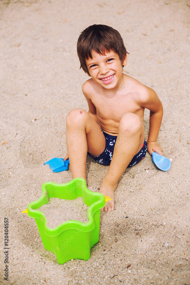 Smiling boy playing in sand Smiling boy playing in sand