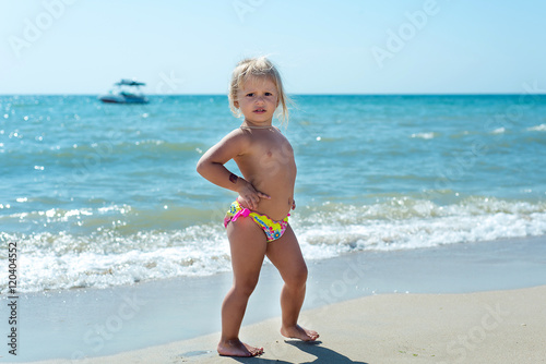 The child, a little girl playing on the beach.
