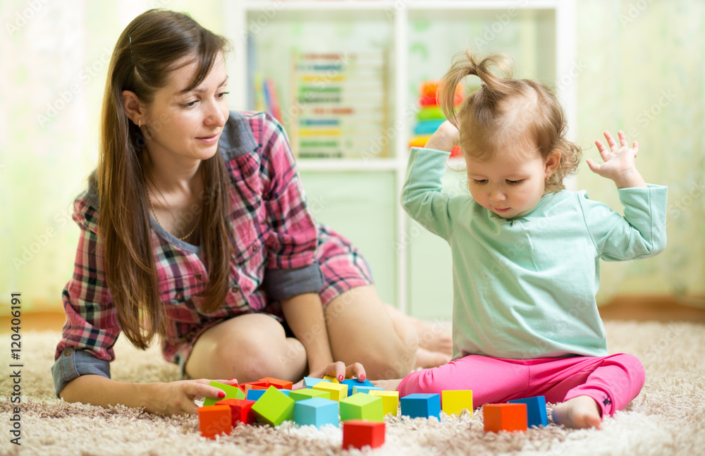 kid toddler and mothet play wooden toys at home or nursery