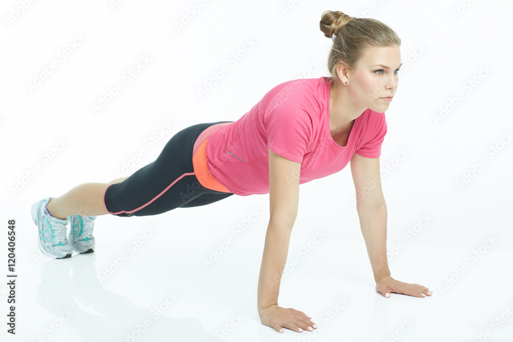 Portrait of a sports woman doing push ups isolated on a white background. Portrait of a sports woman doing push ups isolated on a white background.