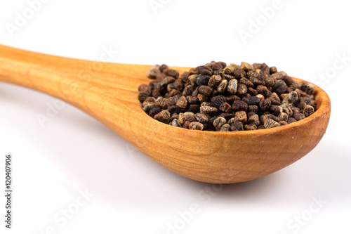 Decorticated cardamom seeds in a wooden spoon