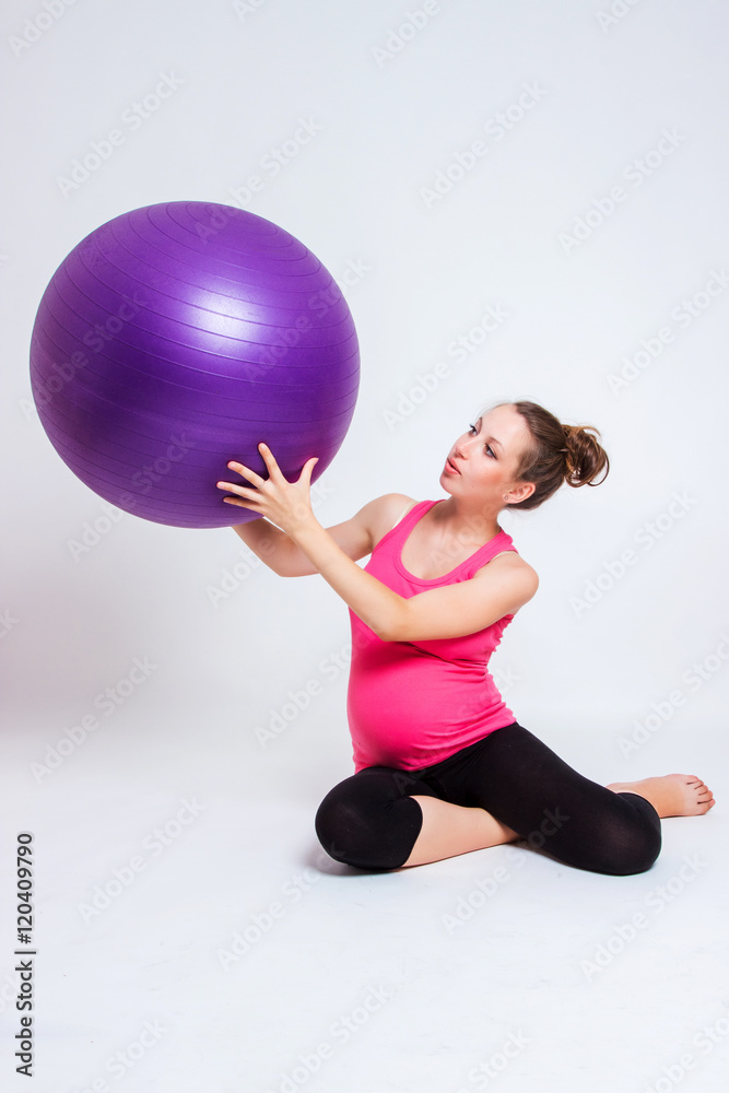 Fototapeta premium pregnant woman practicing yoga on a light background