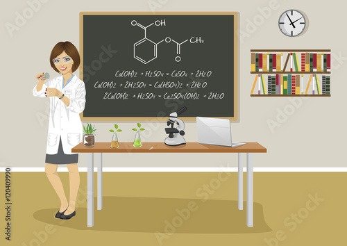 school female teacher giving lecture in chemistry class next to blackboard
